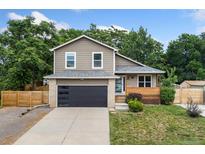 Charming two-story home featuring a modern garage door and cozy front porch at 7120 S Clay St, Littleton, CO 80120
