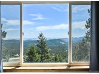 Wonderful mountain views are shown through an oversized window at 8386 S Davco Dr, Morrison, CO 80465