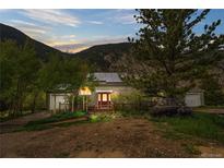 Charming home nestled in the mountains with solar panels, a well-kept yard, and a cozy front porch at 1777 Main St, Georgetown, CO 80444