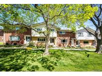 Charming townhomes featuring brick and siding, shaded by mature trees and a well-maintained green lawn at 12632 W Virginia Ave, Lakewood, CO 80228