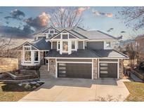 Stunning two-story home with a meticulously kept lawn, gray exterior, stone accents, and a three-car garage at 538 Fairfield Ln, Louisville, CO 80027