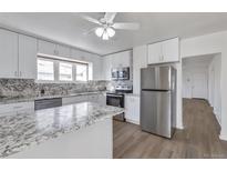 Bright kitchen with white cabinets, stainless steel appliances, and granite countertops at 2918 W 2Nd Ave, Denver, CO 80219