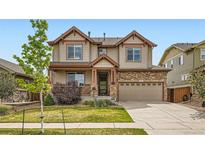Inviting two-story home with a stone facade, covered porch, and well-maintained lawn at 350 N Langdale Ct, Aurora, CO 80018