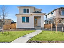Charming two-story home boasts a modern design, well-maintained lawn, and inviting entrance at 21134 E 63Rd Dr, Aurora, CO 80019