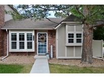 Charming home featuring brick and siding exterior, lovely front yard, and welcoming front door at 9713 W Chatfield Ave # H, Littleton, CO 80128
