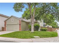 Charming single-Gathering home featuring a lush front yard with mature trees and an attached two-car garage at 9705 Autumnwood Pl, Highlands Ranch, CO 80129
