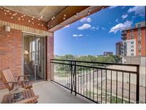 Relaxing balcony featuring brick accents, string lights, and views of the city skyline at 1975 Grant St # 501, Denver, CO 80203