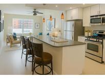 Bright kitchen features a breakfast bar with seating, stainless steel appliances, and opens to the living room at 1975 Grant St # 501, Denver, CO 80203