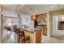 Modern kitchen featuring granite countertops, stainless appliances, and an open concept layout with bar stool seating at 1975 Grant St # 501, Denver, CO 80203