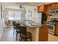 Stylish kitchen with granite counters, stainless steel appliances, and breakfast bar seating at 1975 Grant St # 501, Denver, CO 80203