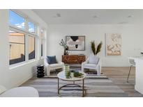 Bright living room featuring modern furnishings, stylish decor, and large windows at 6971 E Lowry Blvd, Denver, CO 80230