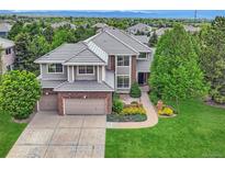 Attractive two-story home with a well-manicured lawn and a two-car garage with gray roof at 10529 Dacre Pl, Lone Tree, CO 80124