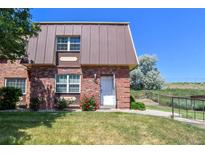 Charming townhome with brick facade, unique roofline, and a well-maintained lawn at 5719 S Lowell Blvd, Littleton, CO 80123