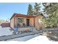 Brick ranch home with a covered porch and well-maintained landscaping at 2990 Sheridan Blvd, Denver, CO 80214