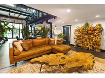 Spacious living room featuring a tufted leather sectional and a unique wood coffee table at 1203 24Th St, Denver, CO 80205
