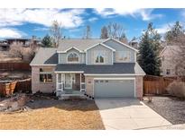 Charming two-story home with a brick facade, well-maintained lawn, attached two-car garage, and inviting front porch at 11932 W 56Th Cir, Arvada, CO 80002
