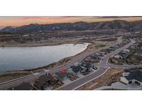 Stunning aerial view of home near a frozen lake with mountain views, located in a desirable neighborhood at 2891 Waterfront Dr, Monument, CO 80132