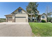 Lovely two-story home with a three-car garage, stone accents, and well-manicured lawn at 2550 Gold Creek Dr, Elizabeth, CO 80107