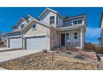 Charming two-story home with a two-car garage and inviting front porch with rocking chairs at 147 Silver Rock Trl, Castle Rock, CO 80104
