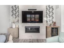 Stylish living room featuring a modern fireplace, TV, and sleek cabinetry with a small wet bar at 10524 Eby Cir, Lone Tree, CO 80124