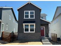 Charming two-story home with a red front door, gray siding, white windows, and a small front yard at 23772 E 33Rd Pl, Aurora, CO 80019