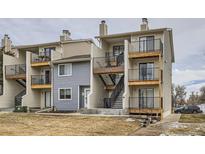 View of townhome complex featuring siding, black iron balconies and stairs to the upper units at 6009 Yarrow St # B, Arvada, CO 80004