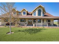 Stunning two-story home featuring a well manicured lawn and a welcoming front porch at 4075 Merada Ct, Franktown, CO 80116