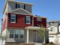 Charming two-story home with red siding, gray stucco, black shutters, and a welcoming front porch at 22023 E 38Th Pl, Aurora, CO 80019