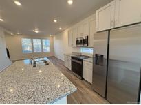 Modern kitchen featuring a spacious island with granite countertops and stainless steel appliances at 22023 E 38Th Pl, Aurora, CO 80019