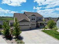 Beautiful two-story home with a three-car garage, landscaping, and an inviting covered front porch at 5929 Echo Hollow St, Castle Rock, CO 80104