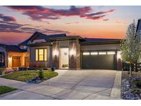 Inviting single-story home with brick accents, garage, and a well-maintained yard at sunset at 6469 Barnstead Dr, Castle Pines, CO 80108