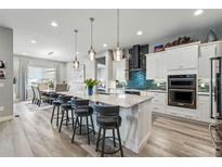 Spacious open-concept kitchen with granite countertops, oversized island, and stainless steel appliances at 6469 Barnstead Dr, Castle Pines, CO 80108