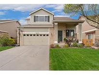 Charming two-story home with a well-manicured front yard and inviting porch at 10475 E Abilene St, Commerce City, CO 80022