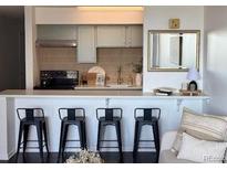 Bright kitchen featuring stainless steel appliances, breakfast bar with seating, and modern finishes at 1020 15Th St # 21M, Denver, CO 80202