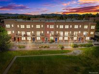 Charming townhome exterior showcasing brick facade, balconies, and mountain views under a colorful sunset at 7848 W 54Th Ave, Arvada, CO 80002