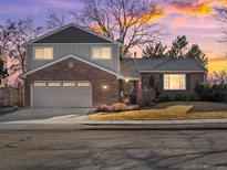 Charming two-story home featuring brick and gray siding, a two-car garage, and a well-maintained front yard at 9930 W 82Nd Ave, Arvada, CO 80005