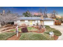 Charming ranch-style house featuring solar panels, well-maintained landscaping, and inviting curb appeal at 7727 W 81St Pl, Arvada, CO 80005