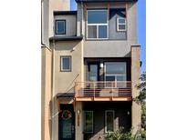 Modern townhome featuring a distinctive facade with mixed materials and a charming Juliet balcony at 10150 Belvedere Loop, Lone Tree, CO 80124