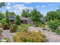 Landscaped front yard with attractive rock ground cover and flowering bushes surrounding a brick home at 2875 Leyden St, Denver, CO 80207