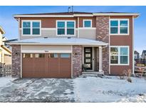 Two-story home with brown brick exterior and attached garage at 9164 Swan River St, Littleton, CO 80125