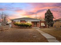Charming single-story brick home featuring a well-maintained front yard under a colorful sunset sky at 1330 Quebec St, Denver, CO 80220