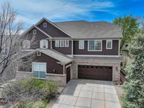 Charming two-story home with brick and brown siding, complemented by a spacious driveway at 12451 Turquoise Terrace Pl, Castle Pines, CO 80108