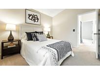Cozy bedroom featuring a comfortable bed with stylish throw pillows and an ensuite bathroom at 1978 Newland Ct, Lakewood, CO 80214