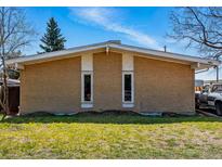 Tan brick exterior showcasing a charming single-story home with two narrow rectangular windows at 1573 S Dexter Way, Denver, CO 80222