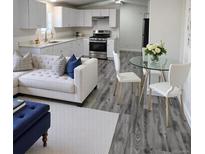 Cozy living room and kitchen with new appliances and modern finishes; ideal open-concept design at 3241 E 84Th Dr, Thornton, CO 80229