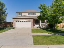 Charming two-story home featuring a brick facade, attached garage, and a well-manicured front yard at 4816 S Elk Way, Aurora, CO 80016
