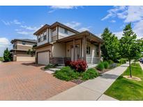 Charming two-story home boasts a well-manicured lawn, vibrant landscaping, and inviting front porch at 10580 Waco St, Commerce City, CO 80022