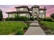 Elegant home featuring a meticulously landscaped yard, stone accents, and a charming walkway to the front entrance at 7724 Kryptonite Ln, Castle Rock, CO 80108