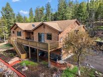 Charming two-story home with a lovely deck and meticulous landscaping in a gorgeous mountain setting at 29825 Kennedy Gulch Rd, Conifer, CO 80433
