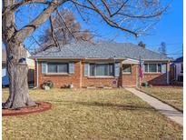 Brick ranch home with mature tree and landscaped lawn at 2916 Ivanhoe St, Denver, CO 80207